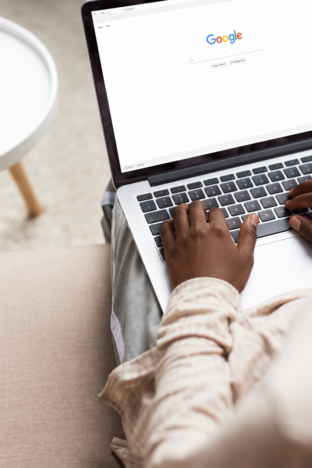 Personne effectuant une recherche Google sur un ordinateur portable dans un salon